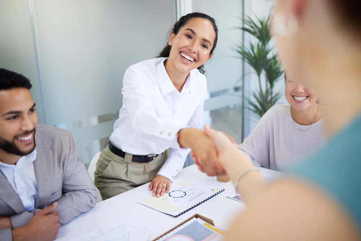 Client and Movaci team shaking hands across a meeting table